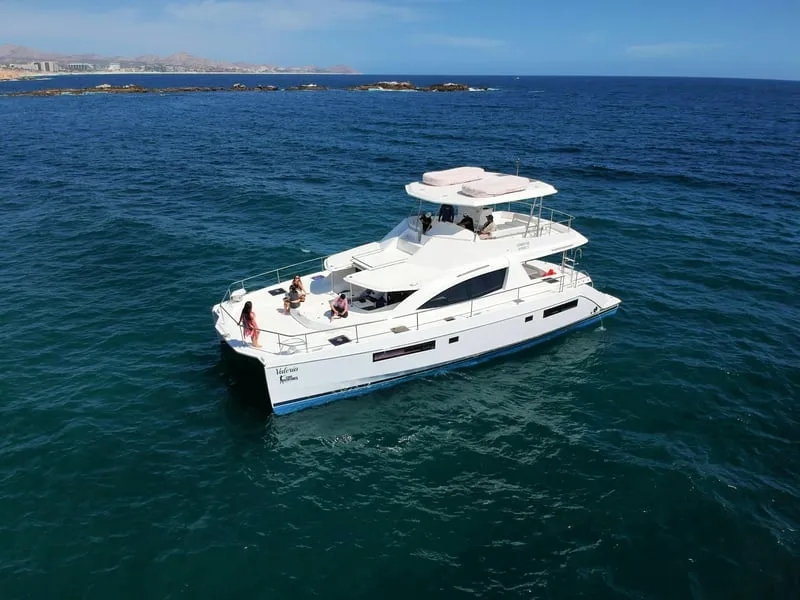 A luxury catamaran anchored over turquoise water on a snorkeling in Cabo San Lucas cruise with lunch