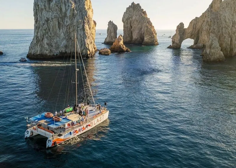 A party catamaran with guests and snorkelers on a snorkeling in Cabo San Lucas open bar cruise